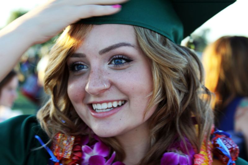 A graduate in her cap smiling mid-celebration.